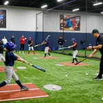 Hit club baseball players training indoors, demonstrating teamwork and skill development.